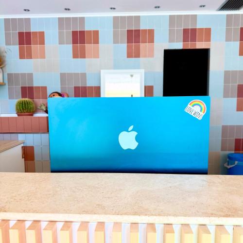 an apple laptop computer sitting on top of a counter at Hotel Blumen in San Benedetto del Tronto