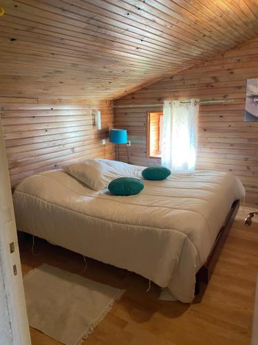 - une chambre avec un grand lit dans une cabane en rondins dans l'établissement Villa Tournesol, à Bourdeilles
