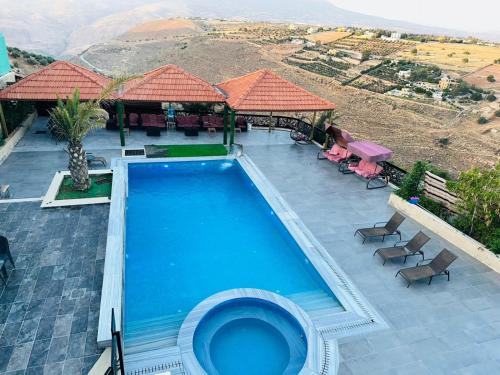 a swimming pool with a view of a mountain at The Royal Chalet in Ath Thukhaynāt