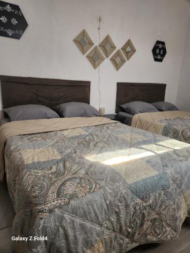 ein Schlafzimmer mit zwei Betten und zwei Uhren an der Wand in der Unterkunft Casa Linda Vista 2 in Cedro