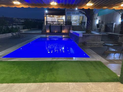a swimming pool in a backyard at night at The Royal Chalet in Ath Thukhaynāt