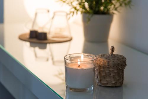 a candle and a glass on a table at Matinee Rooms in Mattinata