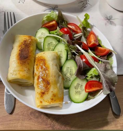 a plate of food with a salad and some food at Hotel-Home Bed&Bike in Bila Tserkva