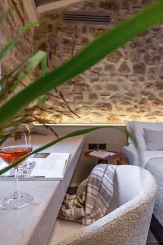 a glass of wine sitting on a table with a couch at ACRO Upscale Residences in Kórinthos