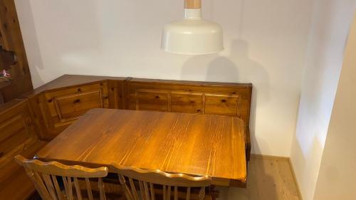 a wooden table with two chairs and a lamp at Il Cadorino in Valle di Cadore