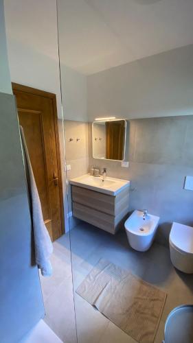 a bathroom with a sink and a toilet and a mirror at Il Cadorino in Valle di Cadore