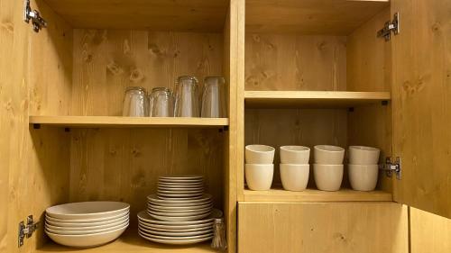 a cabinet with plates and cups and dishes in it at Il Cadorino in Valle di Cadore