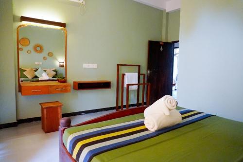 a bedroom with a bed with a towel on it at 7elements - Boutique Hotel & Restaurant in Weligama