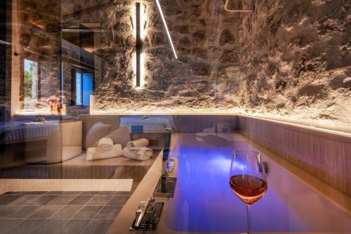 a glass of wine sitting next to a bath tub at ACRO Upscale Residences in Kórinthos