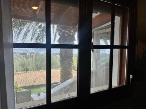 an open window with a view of a palm tree at Blue Panorama Crystal in Mákri