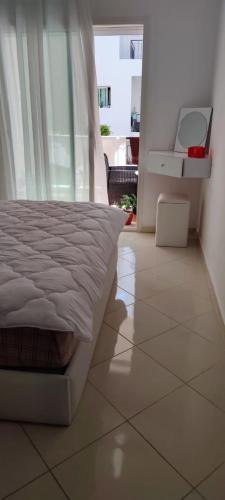 Un dormitorio con una cama y suelo de baldosas. en Al yakoute, en Minaret de Mansuria