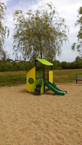 a playground with a green slide in a park at Pescalis Résidence Les Maisons du Lac in Moncoutant
