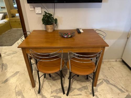 a wooden table with two chairs and a bowl on it at Blue Panorama Crystal in Mákri
