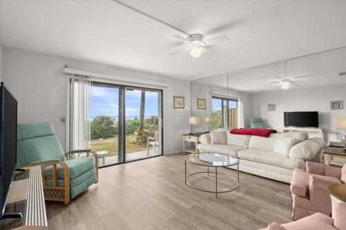 una sala de estar con un sofá y una mesa en Green Palms Oceanfront 2 Bed Townhouse, en Ponce Inlet