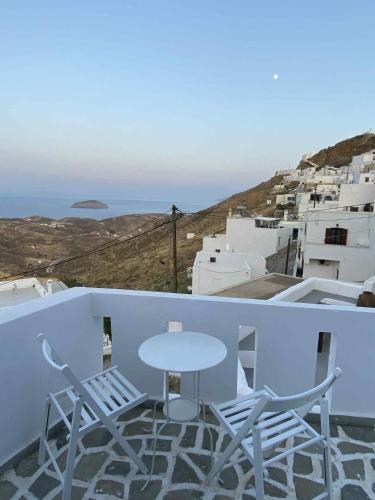 a white table and chairs on a balcony with a view at Chora's Cycladic Aura in Serifos Chora