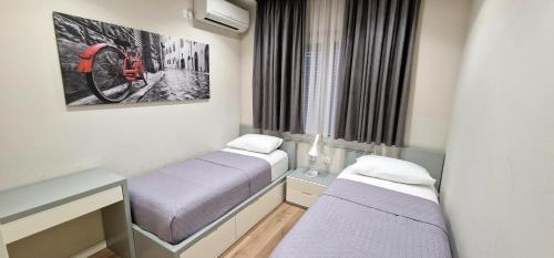 a small room with two beds and a window at Arkle Apartment 1 in Tirana