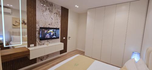 a living room with a tv on a wall at Arkle Apartment 1 in Tirana