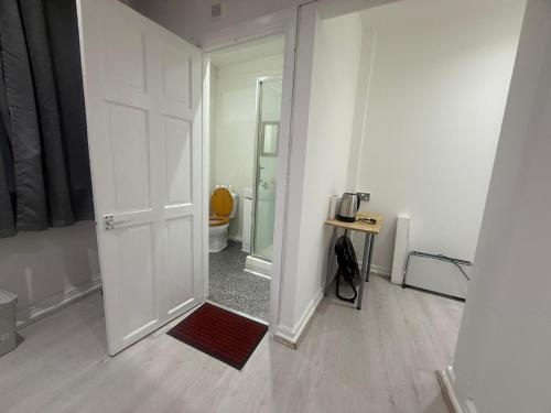 a white room with a door leading to a bathroom at Y2 guest house in London