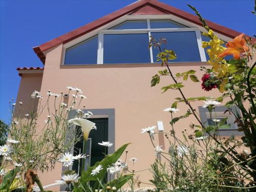 a house with windows and flowers in the foreground at House Vila Santa Ana in Santana