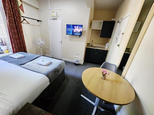 a hotel room with a bed and a table at The Green Light House Studio 24 - Free Private Parking in Portsmouth