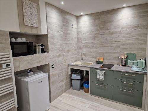a small kitchen with a sink and a microwave at Votre gîte au Domaine du Lynx in Baume-les-Messieurs
