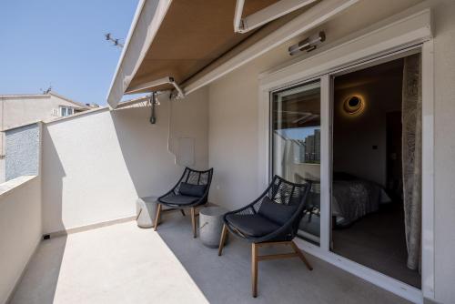 a balcony with two chairs and a bedroom at Guesthouse Rooms Split in Split