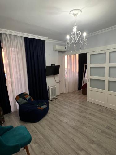 a living room with a couch and a chandelier at Апартаменты Зура 3 in Batumi