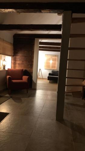 a living room with a red chair and a couch at Damwildfarm in Rollerbü Südschweden in Tyringe