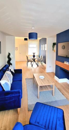a living room with a blue couch and a table at Stunning 2 Bed House, Cleethorpes - Contractors Welcome! in Cleethorpes