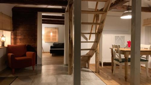 a living room with a staircase and a dining room at Damwildfarm in Rollerbü Südschweden in Tyringe