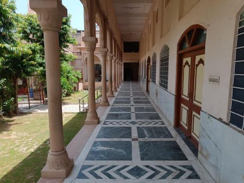 un corridoio di un edificio con colonne e porta di shri gokerneswar guesthouse a Jaipur