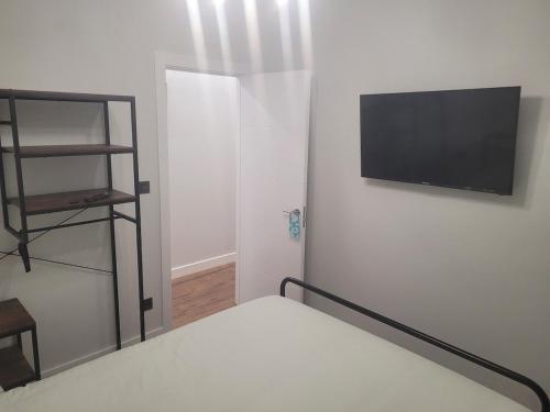 une chambre avec un lit et une télévision sur un mur dans l'établissement Tourist apartment Loiu-Bizkaia, à Loiu