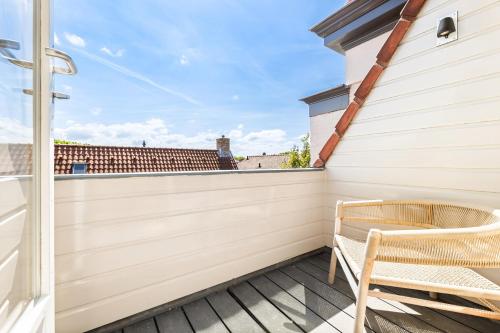 a balcony with a wooden fence and a chair at Hotel Bommelje in Domburg