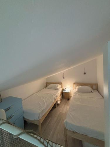 - une chambre avec 2 lits et une table bleue dans l'établissement Appartement 11 en duplex - LES SUITES DE ROBINSON - Résidence avec piscine en bord de Siagne, à Mandelieu-La-Napoule, à Mandelieu-la-Napoule