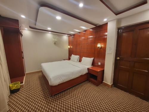 a small room with a bed and a door at Dolphin Lodge in Murree