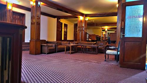 a lobby with a waiting room with leather furniture at Dolphin Lodge in Murree