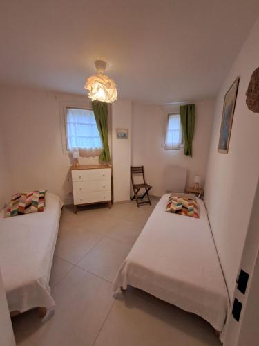 une chambre avec deux lits et un lustre dans l'établissement Saint-Raphaël Beautiful ground floor apartment pool, à Saint-Raphaël