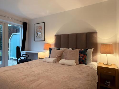 a bedroom with a large bed with a large headboard at Laura's modern 1 bed apartment in Wimbledon in Merton