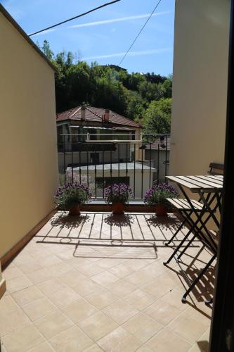 a balcony with a table and chairs and flowers at Agriturismo Dai Marchesin in Nasino
