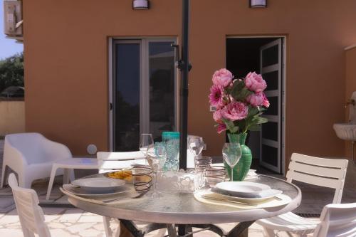 a table with a vase of pink flowers on it at Villa MARTINA in Ortona