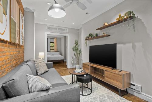 a living room with a couch and a flat screen tv at Stylish Escape in the East Village in New York