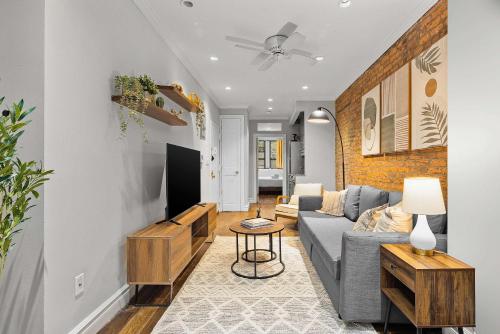 a living room with a couch and a tv at Stylish Escape in the East Village in New York