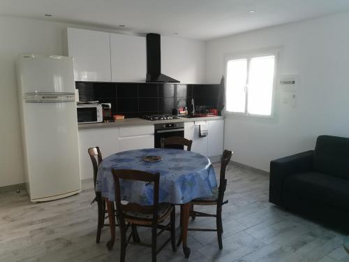 une cuisine avec une table et un chiffon bleu dans l'établissement Au clos Huguette, à La Valette-du-Var