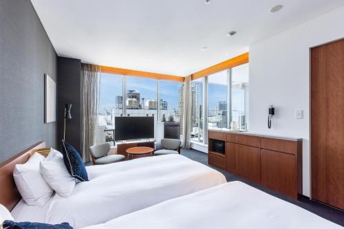 a hotel room with two beds and a television at Tokyu Stay Osaka Hommachi in Osaka