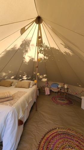 a tent with two beds and two rugs in a room at Nuit insolite tente Grandi'Ose proche Mont Saint Michel in Le Ferré