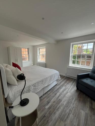 a bedroom with a bed and a table with a lamp at Yugogo One-Bedroom Apartment 37 London Road in St. Albans