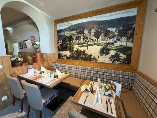 a restaurant with wooden tables and a large painting on the wall at Rathaushotels All Inklusive in Kurort Oberwiesenthal