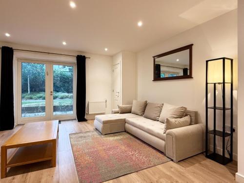 a living room with a couch and a mirror at Laura's modern 1 bed apartment in Wimbledon in Merton