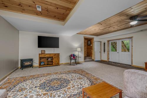 a living room with a flat screen tv and a couch at Otter Manor - Wifi - Fire Pit - Gameroom- Grill - Private Trail in Berkeley Springs