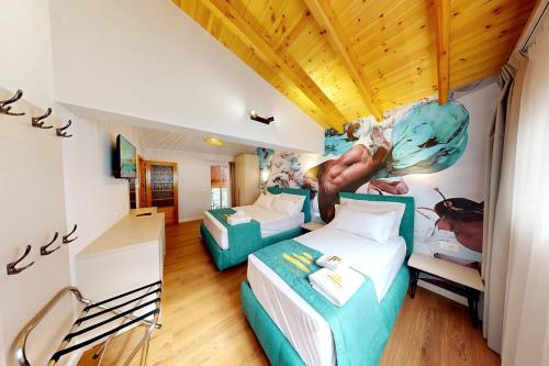 a hotel room with two beds and a mural on the wall at Villa Zen Oasis in Golem